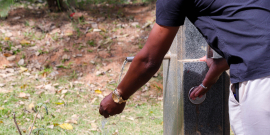 homem retira água de bebedouro público