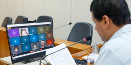 Vereador presidente da reunião conjunta em frente a tela com demais vereadores para apreciar parecer