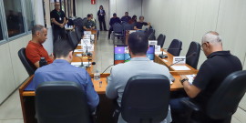 Vereadores reunidos durante audiência pública com cadeiras vazias de convidados ausentes