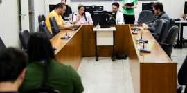 Parlamentares reunidos em volta de mesa durante reunião da Comissão que aprovou parecer favorável ao projeto
