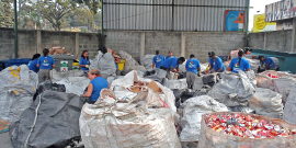 Grandes sacos de lixo reciclável dispostos em galpão