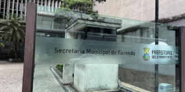 Placa de vidro onde está escrito "Secretaria Municipal de Fazenda" com a logo da Prefeitura de Belo Horizonte ao lado