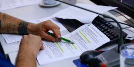 Mãos de vereador em cima de pauta da reunião de comissão na CMBH