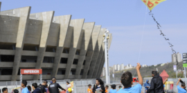 Menino empinando pipa em frente ao Mineirão