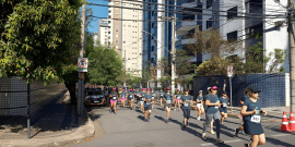 pessoas participam de corrida de rua em via pública