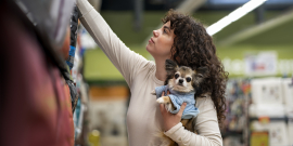 mulher segura cachorro de estimação dentro de supermercado