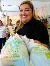 Consumidora portando sacolas compostáveis