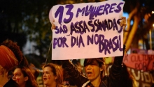 Mulheres fazem caminhada em solidariedade às manifestações feministas na América Latina, que tem países com alta taxa de feminicídio. Cartaz com os dizeres "13 mulheres são assassinadas por dia no Brasil"
