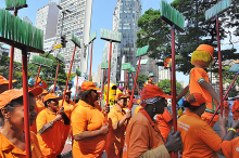 Servidores da SLU, uniformizados, em manifestação pela rua