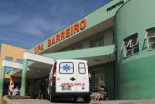 Imagem mostra a fachada da UPA Barreiro, com uma ambulância estacionada na porta