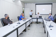 Quatro vereadores estão sentados à Mesa do Plenário Camil Caram, usando máscaras; atrás deles, dois servidores assessoram a reunião