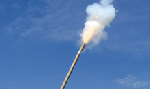 Detalhe de fogo de artifício aceso, com céu azul ao fundo