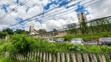 Fachada do Ceresp. Nome escrito no muro. Grade e cerca de arame. Carros estacionados na porta