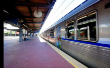 Plataforma de metrô com trem parado, de portas fechadas, durante o dia