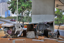 Barraca de lona improvisada, carrinho de supermercado, colchão e caixotes de madeira servem como abrigo para morador de rua