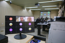 Dois homens dividem tela de computador em reunião remota.
