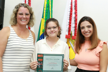 A Presidente da Câmara Nely Aquino e a presidente da Comissão de Educação Marcela trópia entregam à estudante Izabela Santos o certificado de participação do Concurso de Redação da Escola do Legislativo