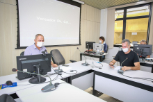 Dois veradores em reunião, ao fundo, dois assessores da Câmara. 