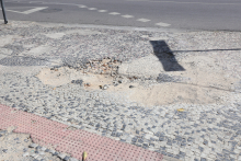 a imagem mostra uma calçada portuguesa com reparo mal feito. é possível identificar o desnível e também terra na parte que deveria estar restaurada