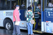 Foto mostra pessoas entrando em um ônibus 