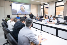 Nove pessoas reunidas, sentadas à mesa, entre parlamentares, representantes da Prefeitura e de instituições civis