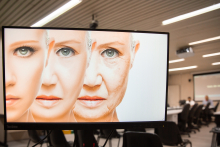Imagem na tela do computador do rosto de uma mesma mulher causasiana em três momentos, identificando a passagem do tempo da vida