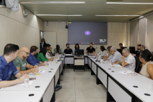 Quinze pessoas reunidas, sentadas à mesa.