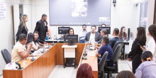Loíde Gonçalves (MDB) e moradores do Novo Lajedo, assentados na mesa em formato de U, discutem urbanização do bairro no plenário Camil Caram. Ao fundo, no telão, representantes da Urbel e Copasa participam da reunião remotamente.