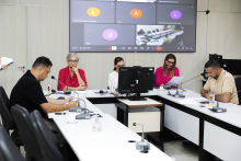 Imagem dos cinco integrantes da Comissão em torno de uma mesa em formato de U 