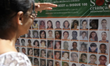 Mulher olha fotos de desaparecidos