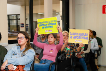 Participantes da audiência mostram cartazes com palavras de ordem