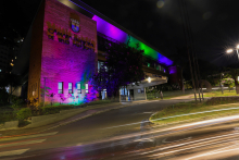 fachada da câmara municipal iluminada nas cores lilás, azul, verde e rosa