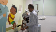 profissional de saúde realiza atendimento oftalmológico em criança
