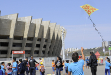 Menino empinando pipa em frente ao Mineirão