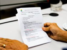 mãos de parlamentar seguram documento de comissão