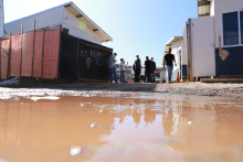 Rua do barreiro alagada e pessoas ao fundo durante visita técnica