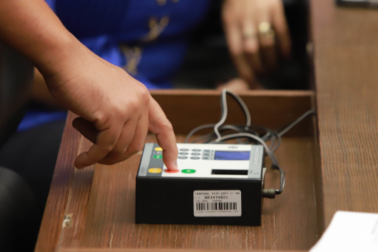 Mão de vereador pressiona botão em aparelho de votação digital da CMBH